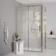 Duschbereich mit transparenter Glastür und Chrom-Duscharmatur von Ideal Standard. Im Vordergrund ein weißer Hocker mit Pflanze und Handtuch an der Wand.